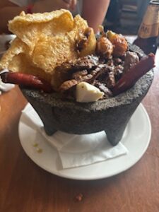 Molcajetes: a stone mortar filled with strips of rib eye steak and topped with chicharron (pork crackling)